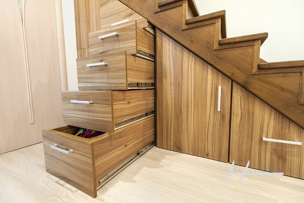 Scala in legno con cassetti portaoggetti integrati aperti, che mostra un uso efficiente dello spazio in un moderno design di interni domestici.