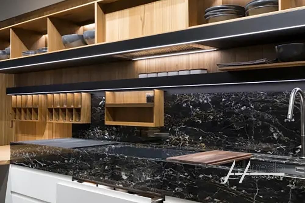 Cucina moderna con ripiani in marmo nero, mobili in legno e scaffali integrati pieni di stoviglie, che mostrano un'estetica da cucina di design.